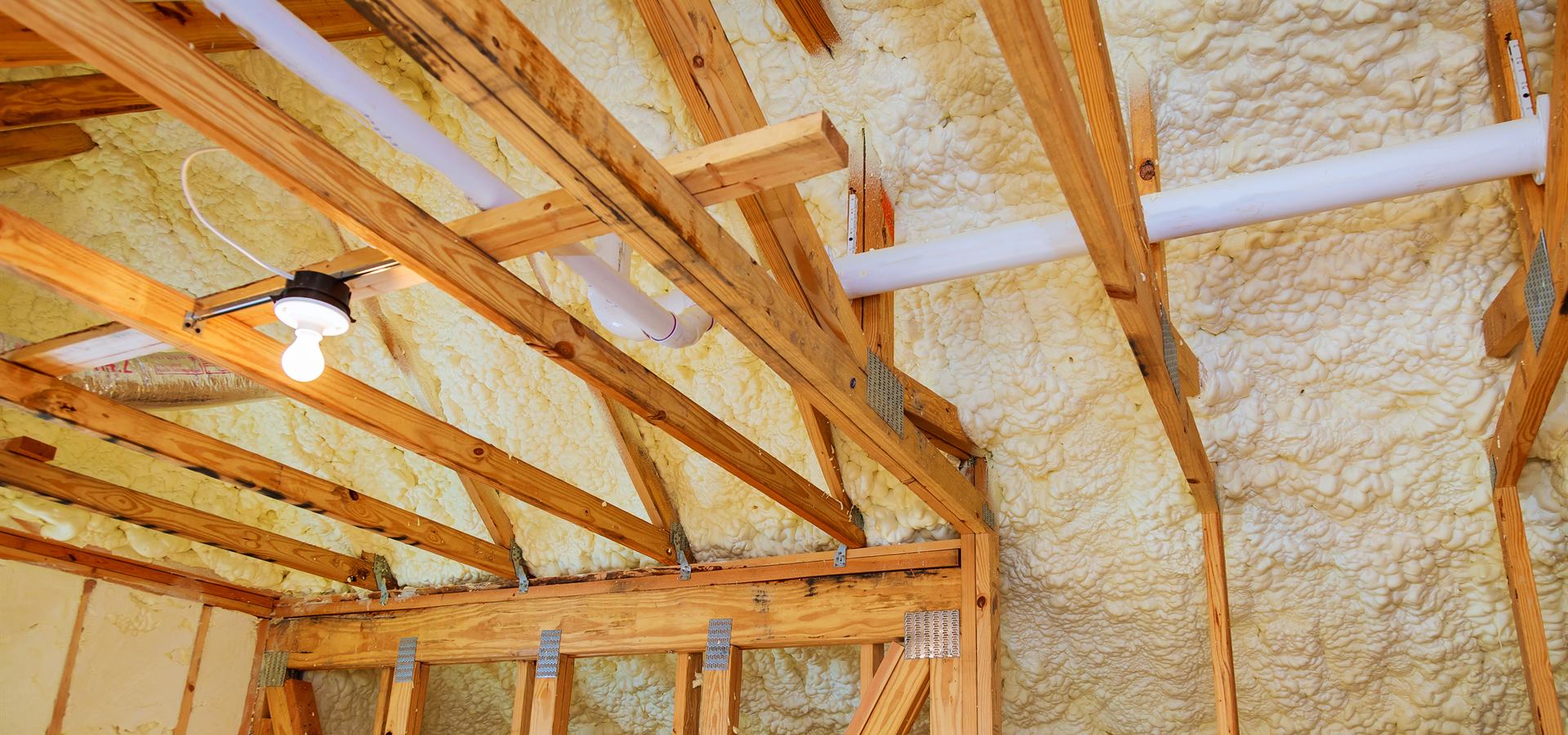 Spray foam insulation sprayed between roof rafters
